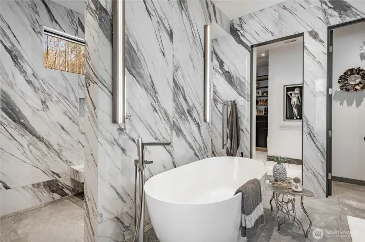 Freestanding tub and walk-in shower, glass free with two entrances. Shower is porcelain thin slab.