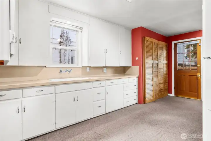 Generous kitchen with amazing cabinet and counter space!  Bifold doors are the washer and dryer, rear door leads to the deck and back yard