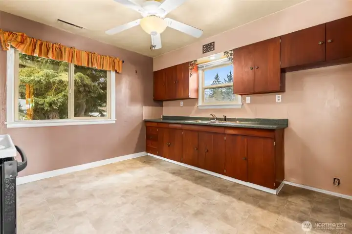 Generous kitchen area with dual windows for natural light - even room for a small cafe table or desk along the back wall