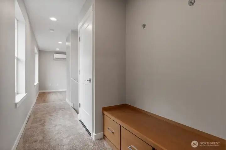 W/D closet next to built in bench with storage