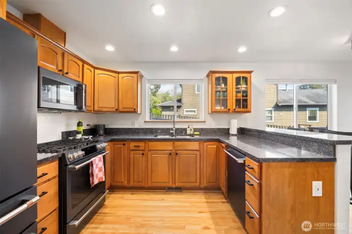 The kitchen is spacious and has the CAFE collection of appliances in matte black to accent the granite counters.