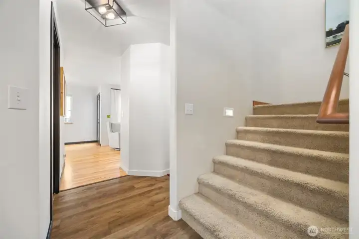 The wide stairway to the bedrooms and full baths has additional lighting.