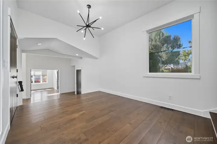 Entry / Foyer -   Bright, open entry with sleek hardwood floors, vaulted ceilings, and direct sightlines through to the main living area.