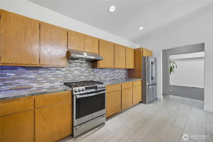 Chef’s Kitchen -  Gourmet kitchen complete with sleek tile backsplash, stainless steel appliances, and plenty of cabinet storage for culinary enthusiasts.