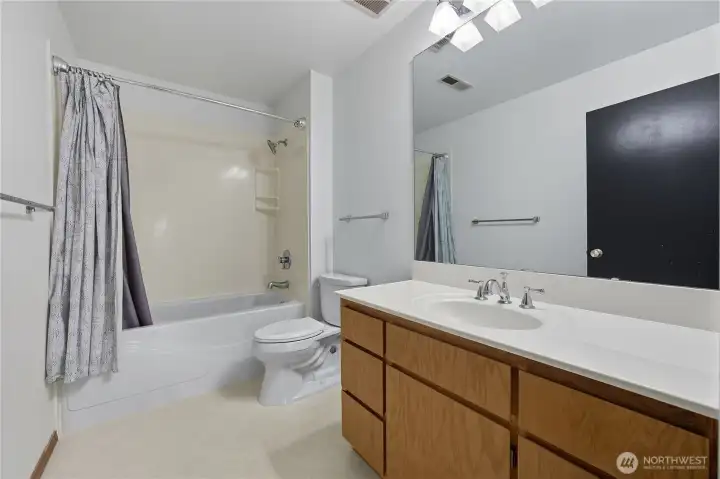 Primary En Suite Bath 1  A bright and functional en suite featuring a full tub/shower combination, updated fixtures, and ample vanity storage — ideal for everyday comfort and convenience.