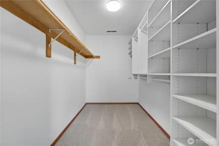 Primary Bedroom #1 Walk-In Closet -   Custom-designed walk-in closet offering generous shelving and hanging space to keep your wardrobe neatly organized.