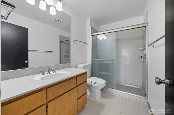 Primary Bedroom #2 (En Suite Bath) -   Sleek and updated en suite bath featuring a walk-in shower, contemporary lighting, and generous counter space.