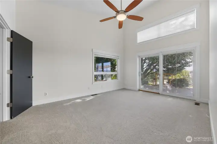 Primary Bedroom #2 -   This versatile secondary suite features vaulted ceilings, oversized windows, and direct access to the private deck, blending indoor comfort with outdoor tranquility.