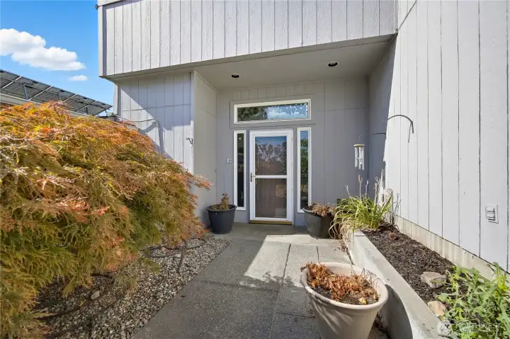 Side Door Entry -   Inviting side entry with mature landscaping and a covered front landing — offering an elegant transition from outdoor to indoor living.