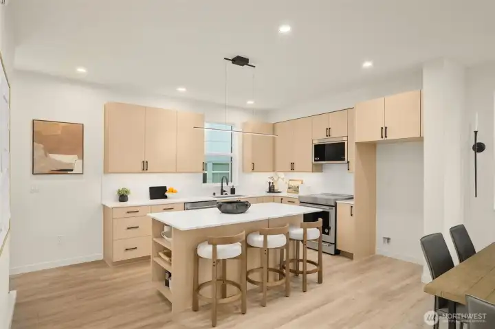 An expansive center island serves as the heart of the home, perfect for casual dining or evening hosting.