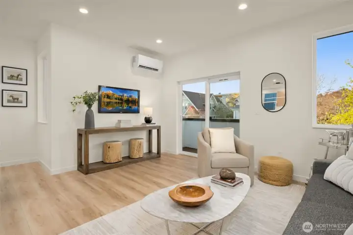 Large windows frame the living area, bringing in plenty of natural light and neighborhood views.