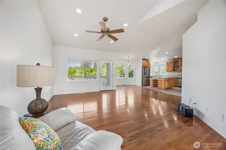 Open family room with vaulted ceilings and gorgeous hardwood floors filled with natural light
