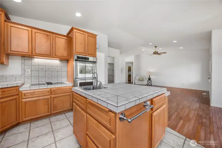 Well-appointed kitchen with stainless steel appliances, double ovens, tile countertops, garbage disposal, and large pantry for storage