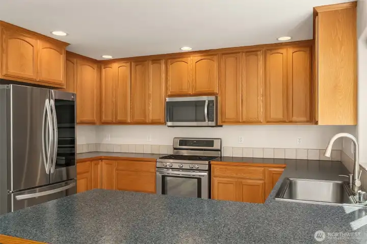 Chef's Kitchen Featuring Wood Cabinets - Breakfast Bar - Stainless Steel Appliances - Gas Range