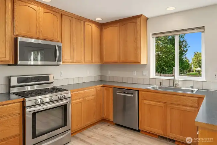 Chef's Kitchen Featuring Wood Cabinets - Stainless Steel Appliances w Gas Range