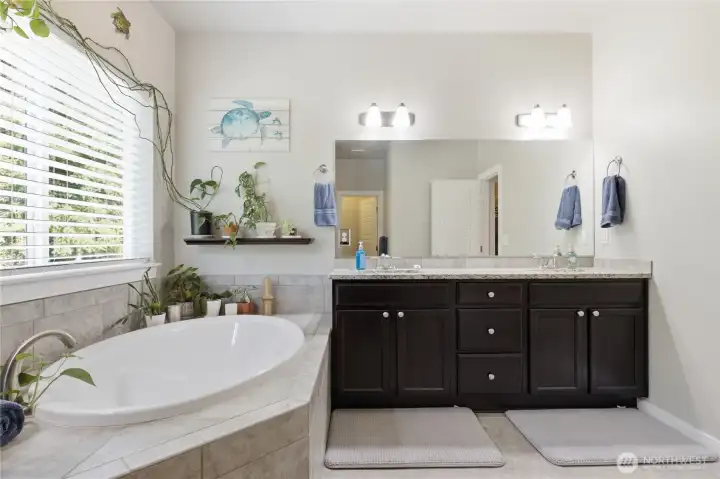 Primary ensuite features two sinks, a soaking tub, and a separate shower