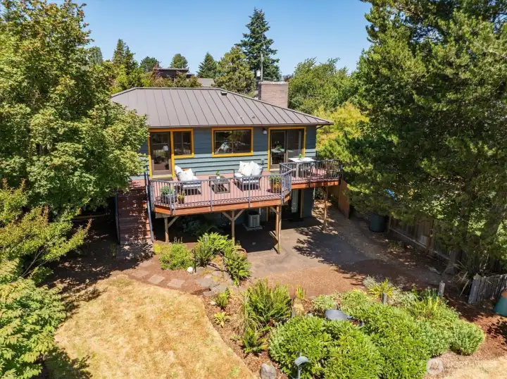 A look at part of the backyard showing the lower patio area and the large trex deck. The house also features a metal roof. A look at part of the backyard showing the lower patio area and the large trex deck. The house also features a metal roof.