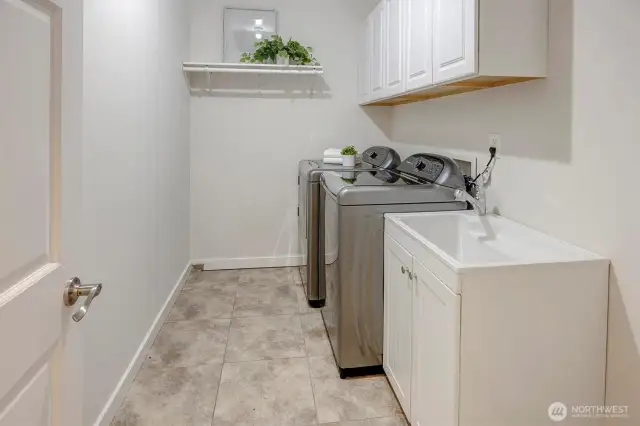 A large utility room with washer, dryer, and utility sink adds convenience.