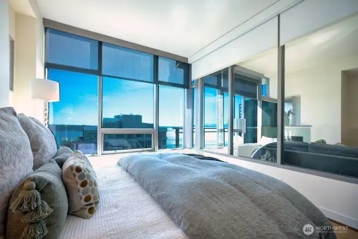 Bedroom with a glass wall and electric shades