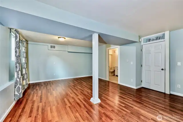Living space in lower level showing entrance to 3/4 bath.