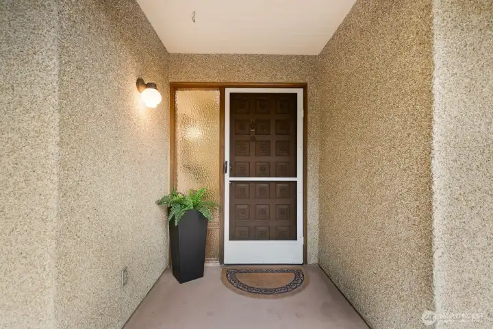 Private ground-floor entry with covered alcove and secure screen door.