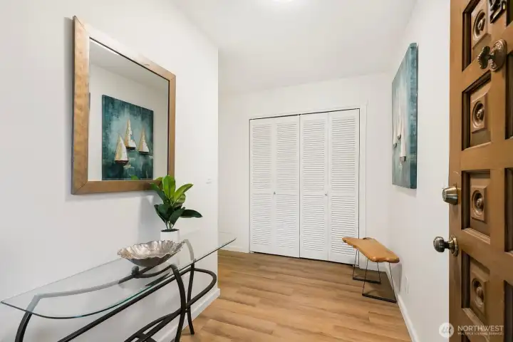 Bright welcoming entry with new LVP flooring and large storage closet.