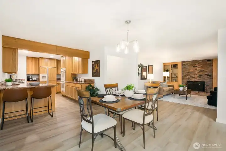 Open-concept dining, kitchen, and living spaces with updated lighting and new flooring throughout.