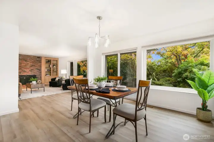 Expansive windows overlook lush greenery, filling the home with natural light.