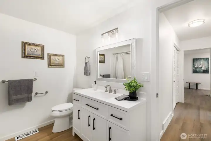 Spacious full bath with refreshed vanity, lighting, and LVP flooring.