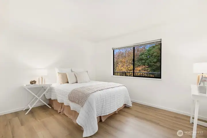 Light filled secondary bedroom with peaceful treetop views and updated flooring