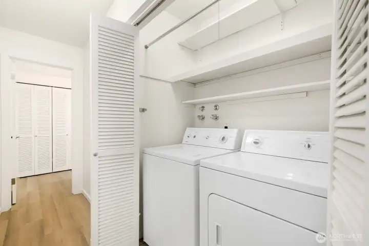 In-unit laundry with full-size washer and dryer plus built-in shelving.