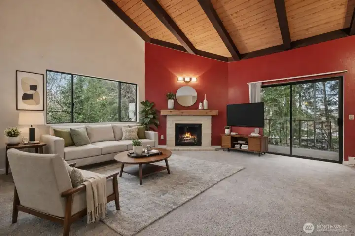 (virtually Staged) Living room with vaulted cedar ceilings, fireplace, large windows, and balcony access.