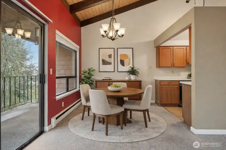 (Virtually Staged) Dining area with vaulted ceilings, large windows, and open flow to the kitchen and living space.