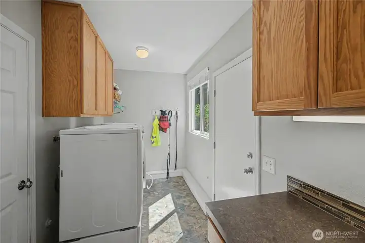 Utility room with storage and access to backyard.