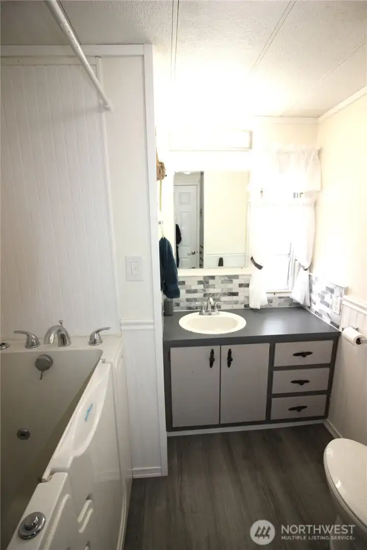 Main bath with jetted walk in tub. Handicap