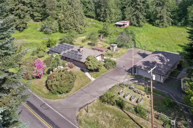 Drone Shot of property, house of left with solar panels, shop on right.
