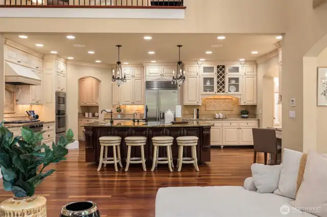 Central Island with Breakfast Bar seating, vegetable prep sink, and Bagatelle chandelier pendant lighting