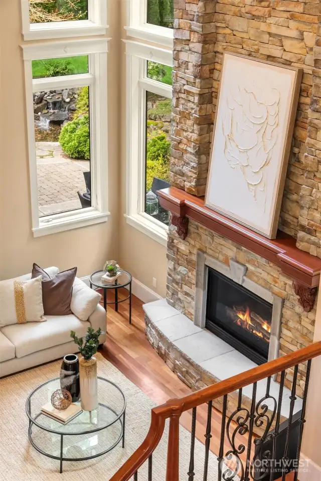 Focal full-height stone fireplace with custom mantel and raised hearth