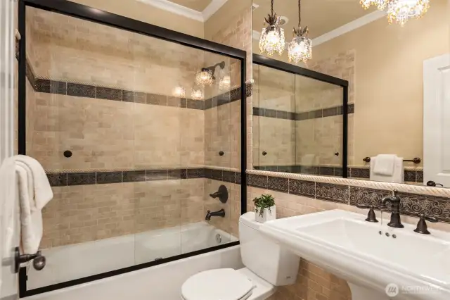Recreation/Guest Level full bath with stone surround and wainscoting, designer accents