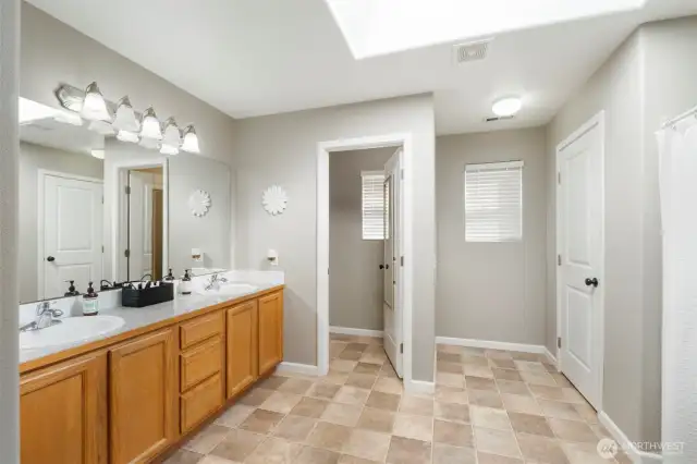 The Primary private ensuite bathroom offers dual vanities, shower, water closet and storage closet.