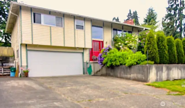 Curb appeal with mature shrubs and character.