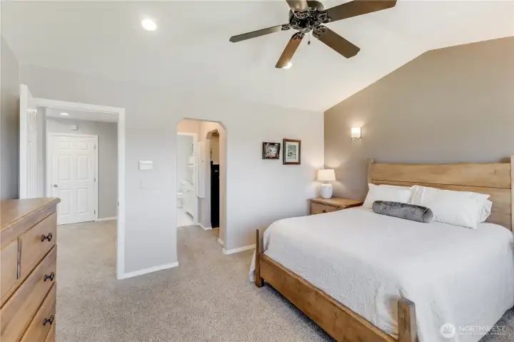 Primary Suite with vaulted ceilings with walk-in closet, closet with shelving & 4 piece bath