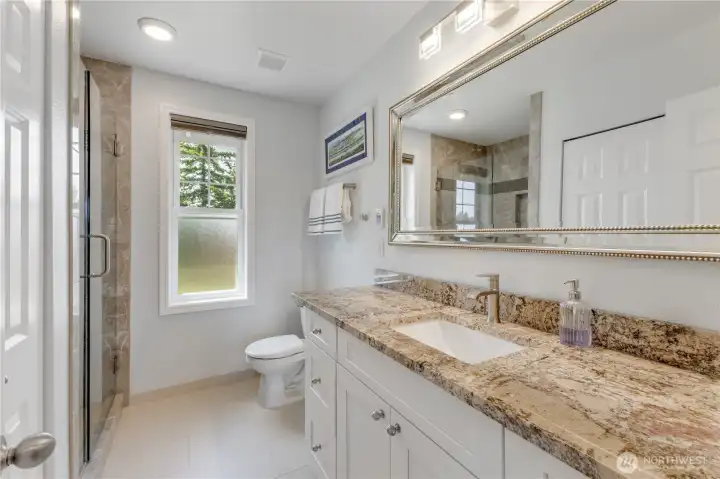 Primary bathroom has heated floors, large granite countertop & ample storage