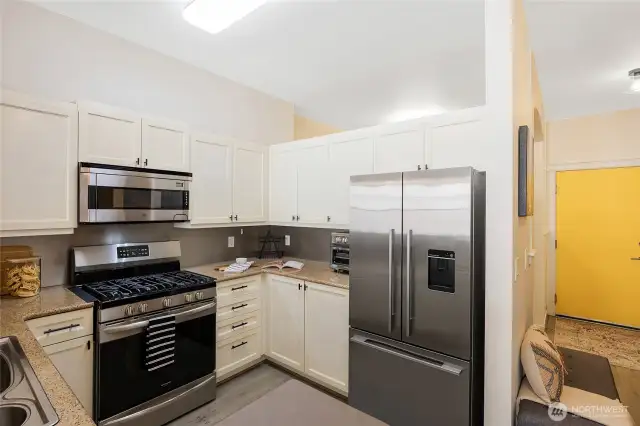 The kitchen features a rare gas stove—hard to find in condos—plus ample counter and cabinet space.