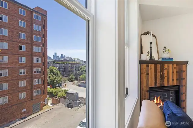 Catch a glimpse of the Seattle skyline from the living room window—just beside the warm glow of the gas fireplace.