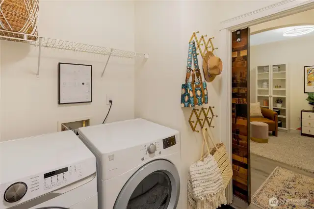 Additional storage can be found above the washer and dryer, with a view into the den just across the hall.