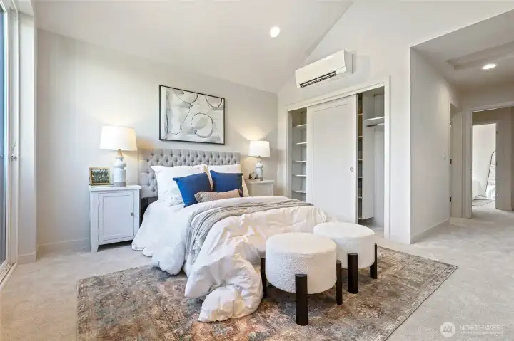 A full view of the spacious primary bedroom, complete with dual closets and ductless mini-split for personalized comfort year-round.