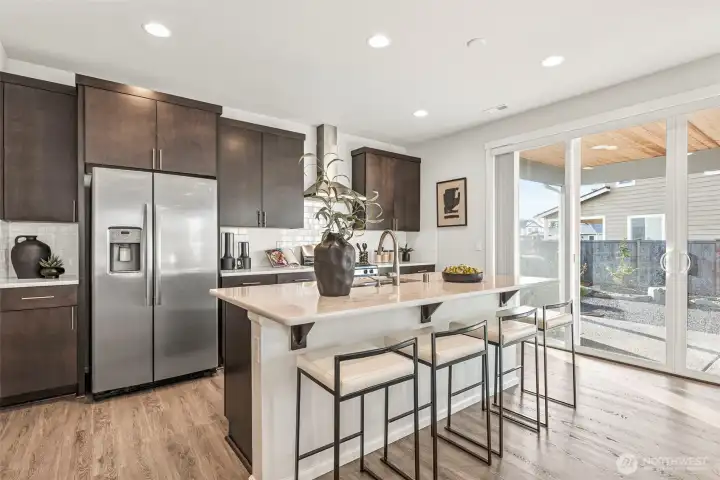 Kitchen with stainless appliances, pullout cabinet drawers and custom pantry.