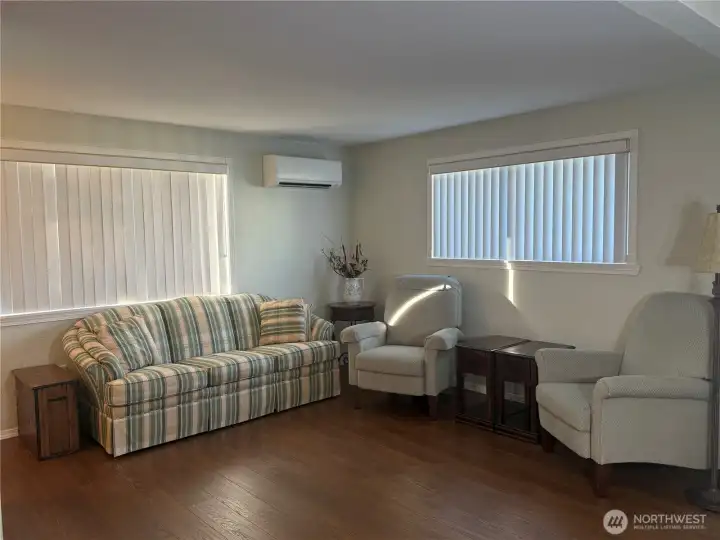 Living room with lar.ge window facing the front of the house and smaller window to side yard. Ductless mini splitter for heat and AC