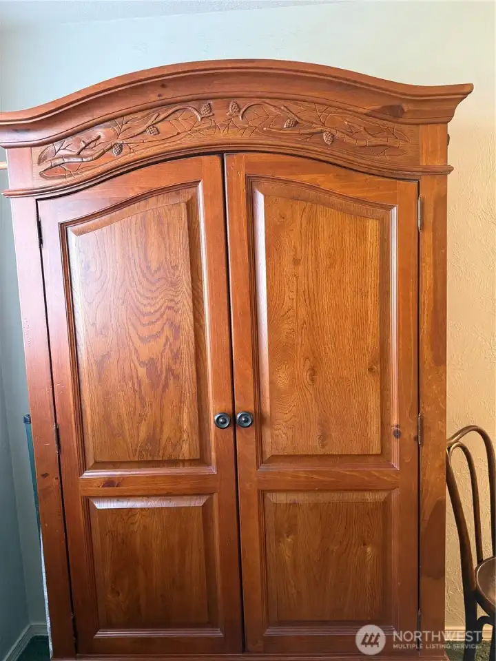 Armoire stays with the purchase of the condo unit for added storage.